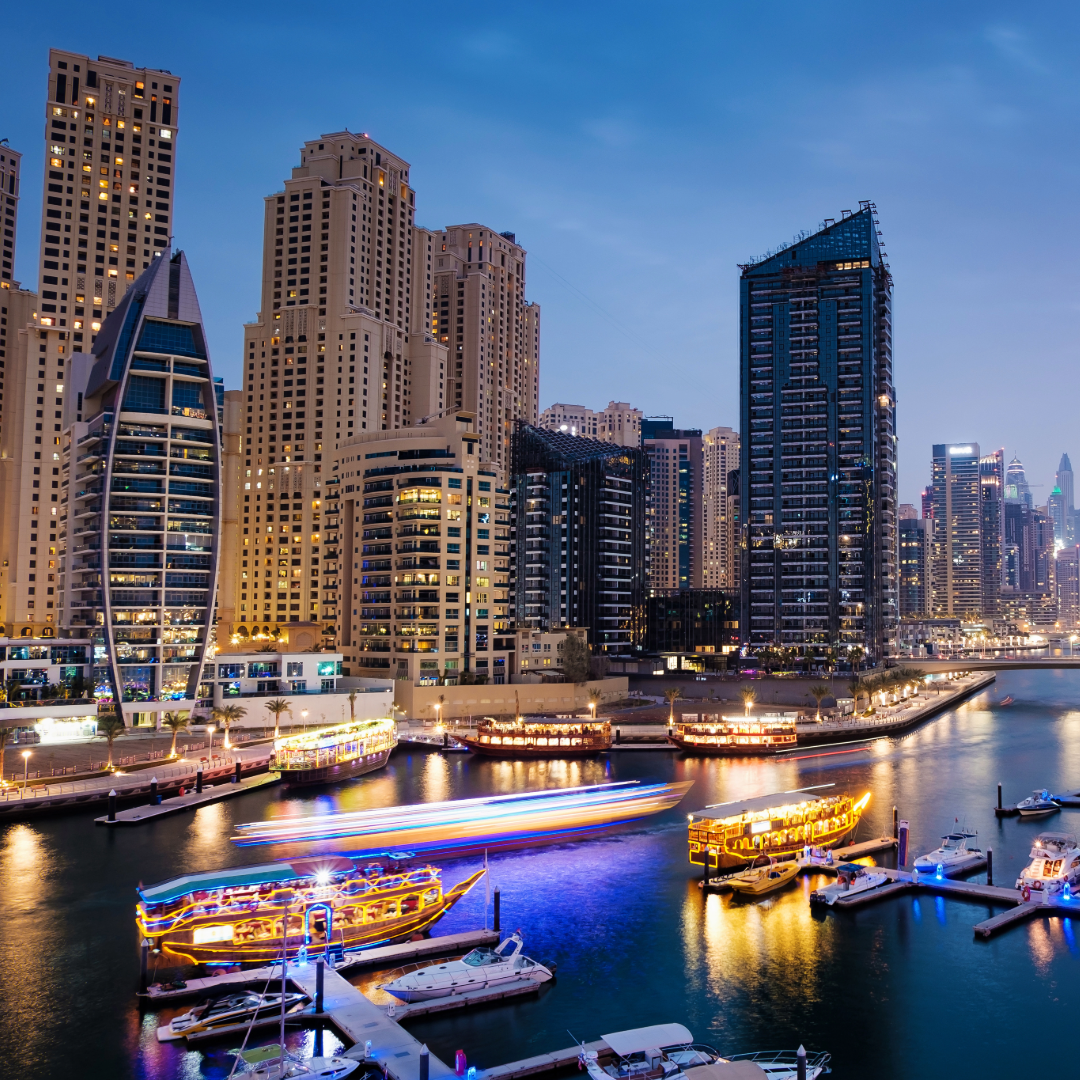 Yachts docked at Dubai Marina with the city skyline in the background.